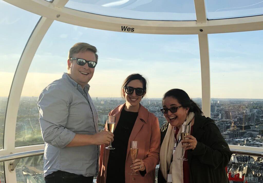 Three people enjoy Champagne on the London Eye during a corporate event