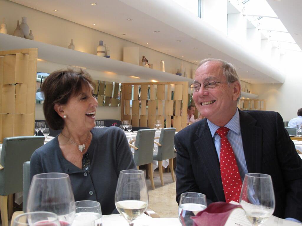 Middle-aged couple smiling as they enjoy a meal