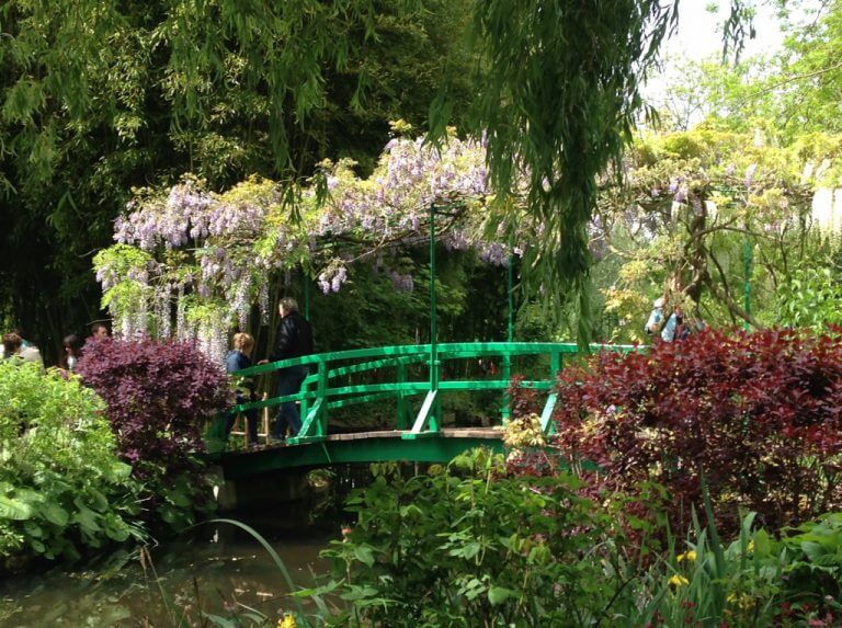 Green bridge over stream with wisteria in garden of Giverny