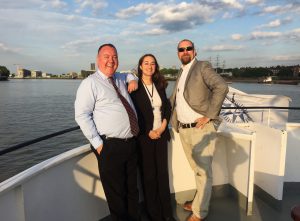 Three people enjoying a corporate evening event on a Thames river cruise