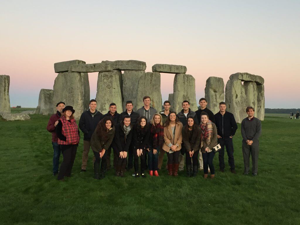 Group of students on educational with Stonehenge behind them