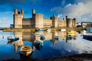 View of Caernarfon Castle and the Menai Straits with boats in the foreground