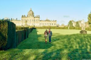 Castle Howard, a historic building designed by Sir John Vanbrugh and built between 1688 and 1712. A couple walking in the grounds.