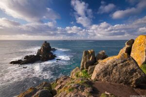 Longships Lighthouse and the Armed Knight rock formation in the sea off the coast of Land's End, the westernmost point of mainland Cornwall.