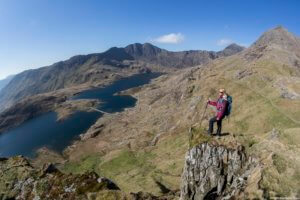 A woman standing on a rock on the slopes of Mount Snowdon