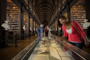 A girl in a library looking at a display case where documents are displayed