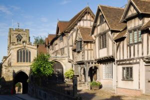 The Lord Leycester Hospital, Warwick, Warwickshire, UK. Exterior view of The Lord Leycester Hosptial. Partial view of West Gate and Warwick Castle. Tudor style architecture. Independent charity providing housing to ex-servicemen and their wives.